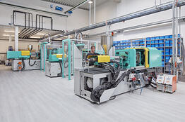 Employee works on injection molding machine